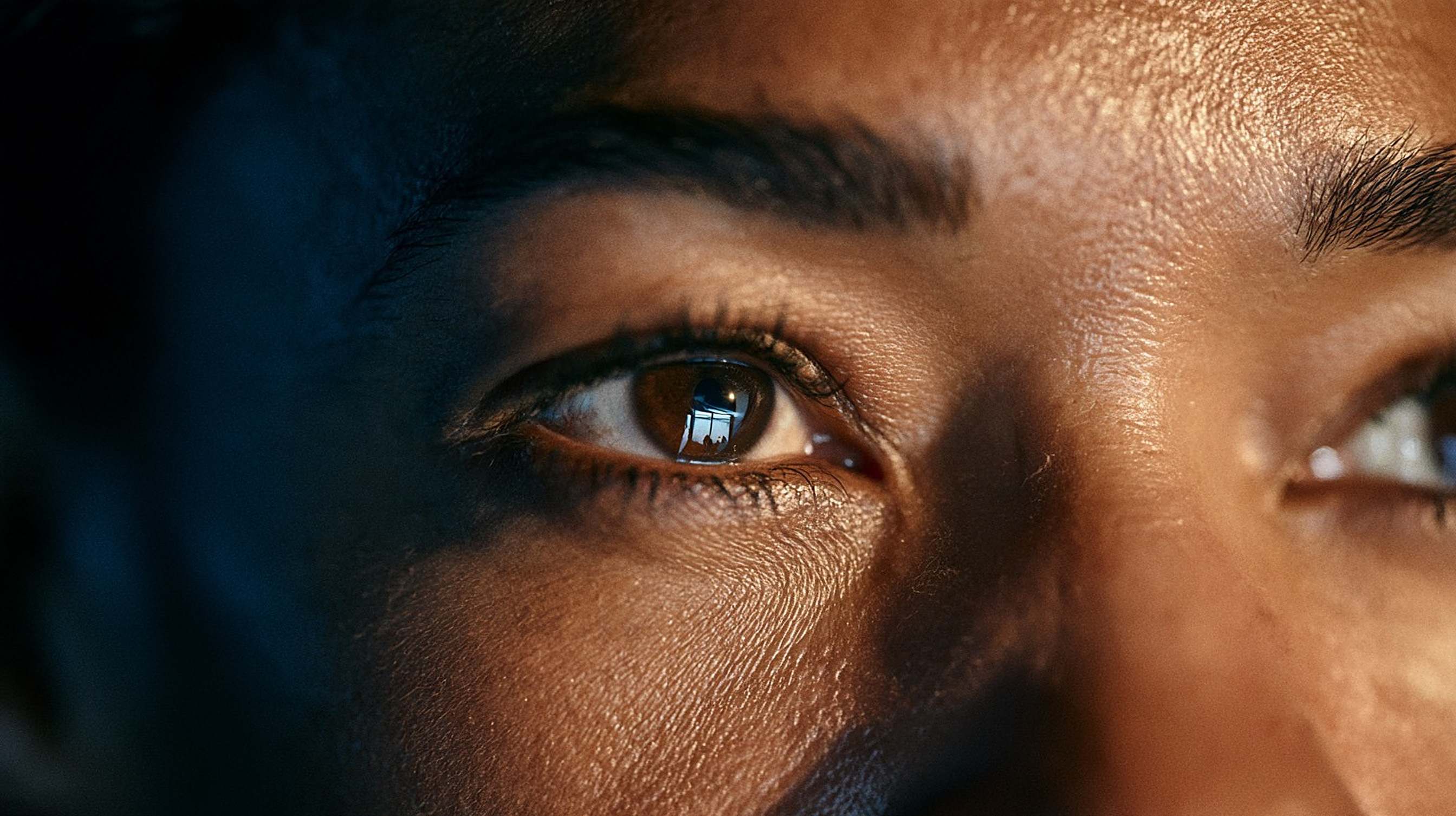 Close-up of an editor’s eyes lit by a screen, in total concentration.